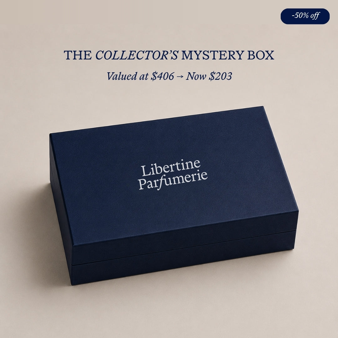 A navy blue rectangular box with white text reading 'Libertine Parfumerie' on a light beige background. Above the box, text reads 'THE DISCOVERY MYSTERY BOX' and 'Valued at $157 -> Now $79', with a small '-50% off' badge in the top right corner.