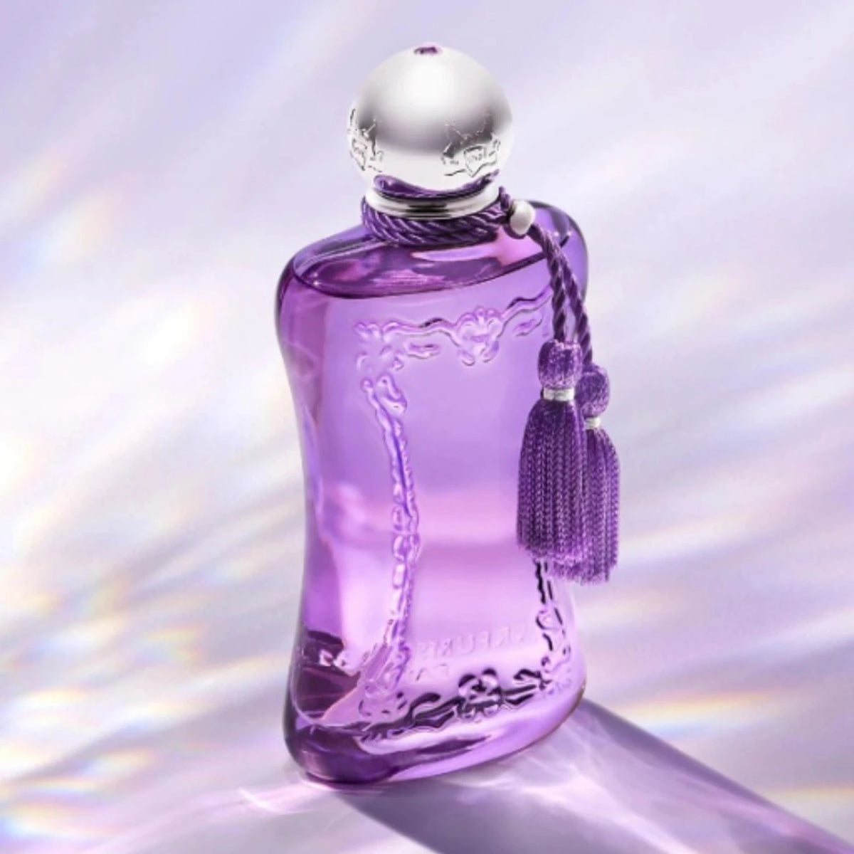 Parfums de Marly Palatine Eau de Parfum bottle in translucent violet glass with a polished silver cap and lavender tassel, illuminated by soft iridescent light.
