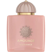 Amouage Guidance perfume bottle in a soft pink color with a metallic gold band and a ribbed champagne-colored cap, shown on a plain white background.